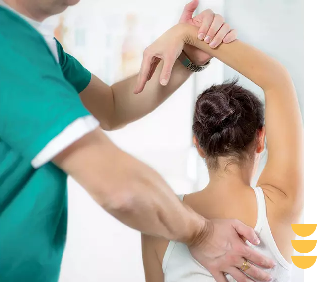 A person is stretching while being held by a doctor.